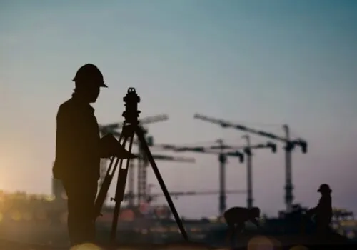 The silhouette of a civil engineer performing land surveying services
