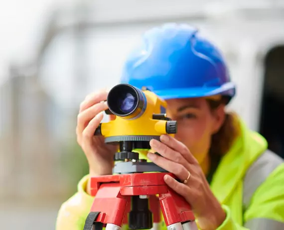 A woman performs land surveying, which is one of the services Austin Engineering, a Civil Engineering Companies in Moline IL, offers